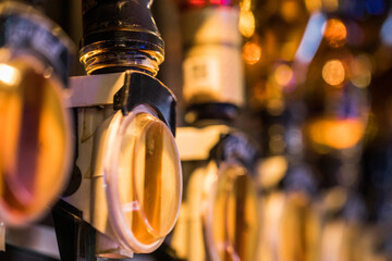 Close-up of illuminated beer taps at a bar