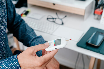 measuring his blood glucose level in the office