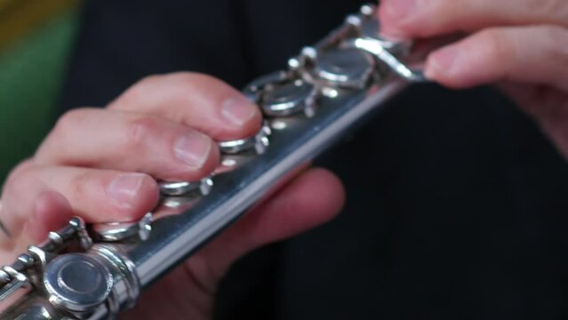 Symphony orchestra brass section. Close up hands of flute player