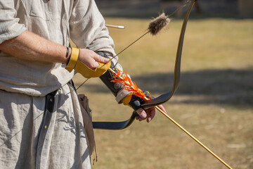 Medieval archery equipment, bow and arrow in the hands of a man
