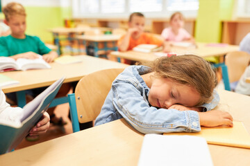 Tired schoolgirl sleeping on bench in class
