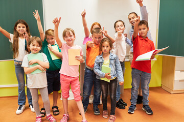 Happy school kids gesturing in class