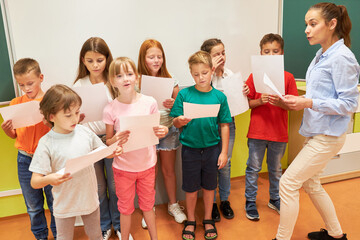 School teacher singing choir with students