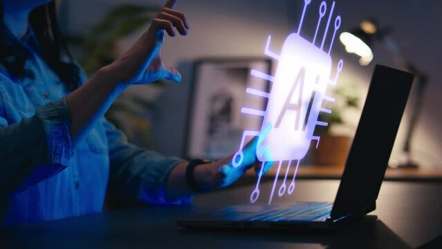 Close up of woman at home interacting with AI graphic projected on virtual computer screen on laptop using pinch and swipe gestures at night - shot in slow motion
