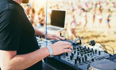 Dj mixing music at beach party during summer event - Entertainment and holidays concept -  Focus on right hand