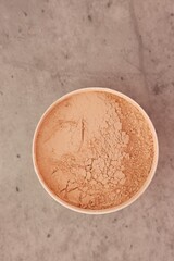Face powder on grey textured table, top view