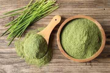 Wheat grass powder and fresh sprouts on wooden table, flat lay