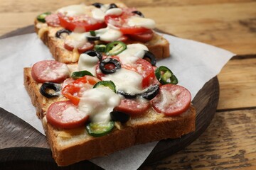 Tasty pizza toasts on wooden table, closeup