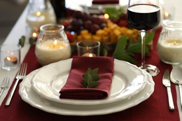 Stylish table setting with burning candles and wine, closeup. Romantic dinner