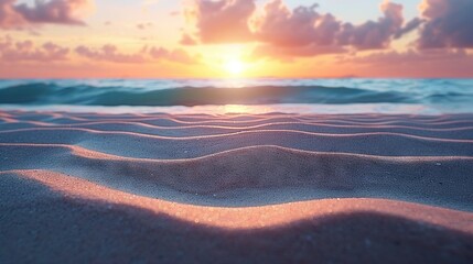   The sun descends over the ocean as sand swirls in the foreground and waves lap at the shore