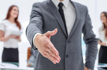 Businessman extending hand for handshake in the office background