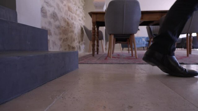  Richly dressed exec enters an old house, his shiny shoes adding a touch of luxury to the rustic setting