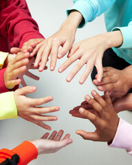 Diverse children's hands keeping safe, protecting something against grey background. Concept of youth, expression, beauty, emotions, gestures, art and symbolism, diversity. Ad