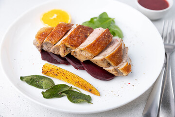 Files of the breast duck grill with beets, mini corn and spinach, fried sage, orange and lingonberry sauce. Traditional Mediterranean cuisine. Selective focus, close-up.