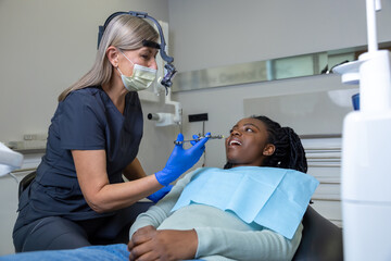 Female dentist making an anesthetic injection before tooth treatment