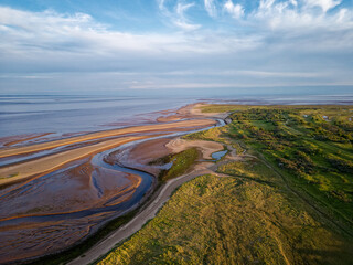 Coastal sunset scene. Aerial photograph showing tidal channels flowing through sand dunes....