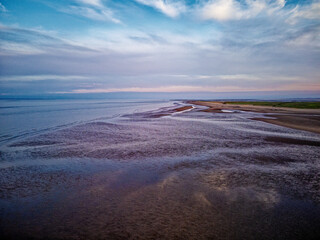 Coastal sunset scene. Aerial photograph showing tidal channels flowing through sand dunes. Lincolnshire Coast, Gibraltar Point. Summer evening sunset
