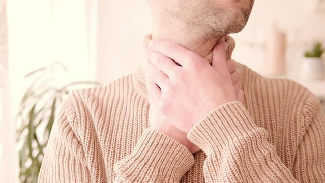 close-up young male neck, man patient holding affected area, experiencing throat pain, Health concern, loss of voice, various causes, medical attention and treatment for condition, tonsillitis