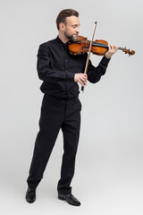 Full length of handsome man violinist performing on concert