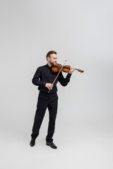 Adult man in black shirt playing violin