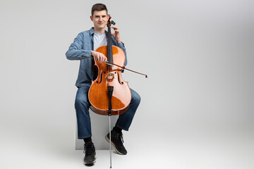 Attractive man musician playing cello on concert