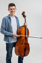 Young man wearing casual clothing playing cello