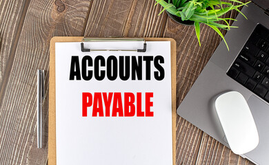 ACCOUNTS PAYABLE text on clipboard paper with laptop, mouse and pen
