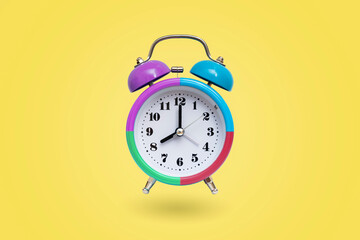 Colourful alarm clock isolated on yellow background