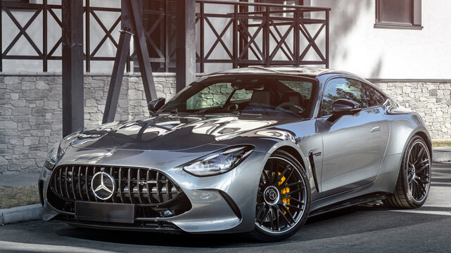 Novosibirsk, Russia - April    23,   2024 : silver  Mercedes-Benz  AMG GT 63 S 4MATIC  ,  front    view,   against  city  in  summer  time