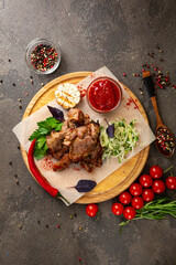 Pieces of grilled meat on a board and fresh vegetables top view