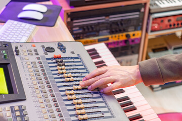 male sound engineer hand adjust fader on digital mixing console in recording studio - obrazy, fototapety, plakaty