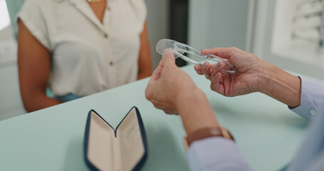 Obraz premium Glasses, optician and hands of person at shop for choice, decision or client buying. Closeup, optometry or customer at store with lens for spectacles, frame or eyewear on sale for healthy vision