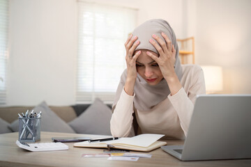 Muslim woman calculate using calculator and invoice bill document with stress young muslim woman...