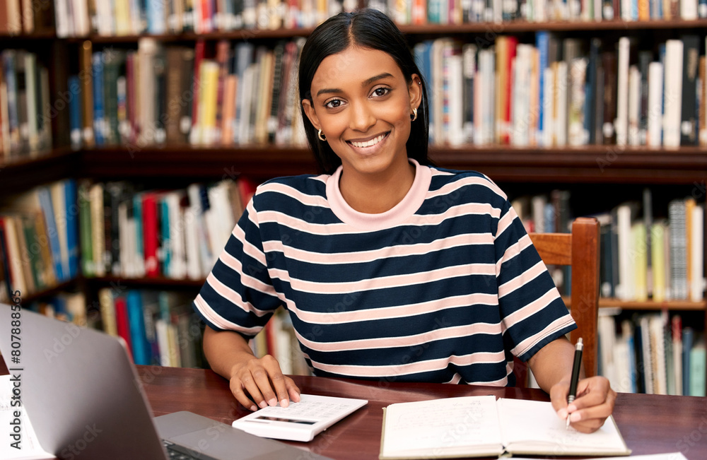 Wall mural Portrait, university and woman in library with laptop, notebook and calculator to finance student loan. Smile, notes and girl with research for scholarship budget, study funding or tuition planning.