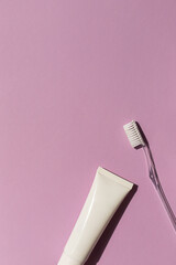 Dental care concept frame with toothbrush and toothpaste on the bright violet background. Copy space