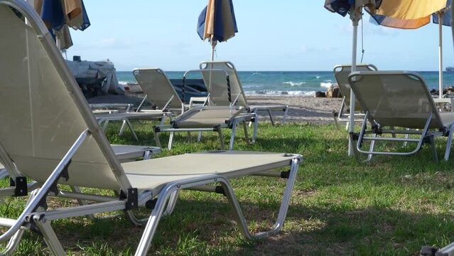 lounge chairs and sunshades on the shore and beach of ARgassi , Zakynthos