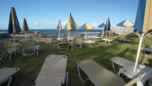 lounge chairs and sunshades on the shore and beach of ARgassi , Zakynthos