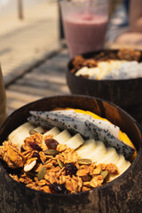 Smoothie Bowl in a coconut bowl with various kinds of fruits at the beach in. ko pangan