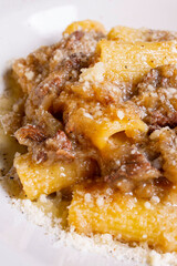 Rigatoni con sugo di genovese napoletana fatta con cipolle e carne e guarniti con formaggio grattugiato serviti come primo piatto in un ristorante 
