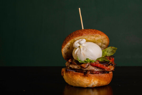 Panino da pub ripieno di hamburger di manzo, melanzane a funghetto, basilico fresco e burrata pugliese