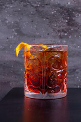 Cocktail Neuroni con ghiaccio guarnito con una buccia di arancia a forma di spirale 