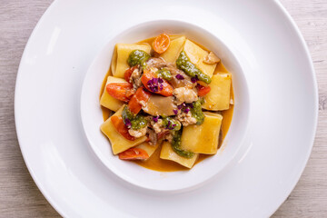 Piatto di Paccheri napoletani con funghi, salsiccia, pesto e pomodori serviti in un ristorante elegante come primo piatto