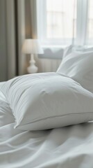 White pillow on a bed with a white blanket. Vertical baclground 