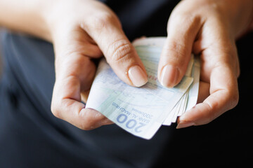 Hand holding Moroccan banknotes, dirham official currency of Morocco.
