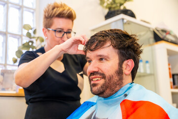 Hairdresser placing a capillary prosthesis to a bald man