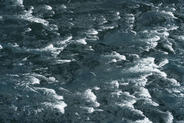 Large river seen from above. Texture of waves rippling the water surface. Nature, backgrounds, wonders, natural patterns.