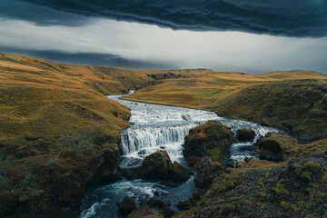 Skógá River under a stormy sky. Long river runs through the Highlands of Iceland, summer storm,...