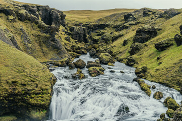 Skógá River under a stormy sky. Long river runs through the Highlands of Iceland, summer storm, climate change. Creation of the famous Skógafoss waterfall.