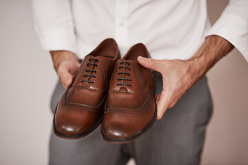 Leather shoes, hands and businessman in studio for dressing, preparing and professional for work....
