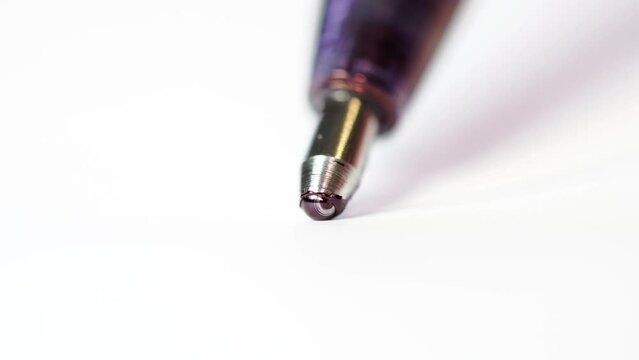 A ballpoint pen writes. Close-up of the ball spinning.